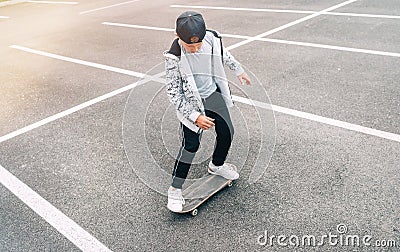 Teenager skateboarder boy with a skateboard on asphalt playground doing tricks. Youth generation Freetime spending concept image Stock Photo