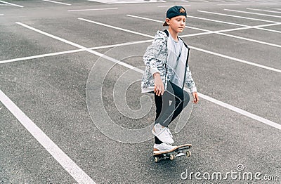 Teenager skateboarder boy with a skateboard on asphalt playground doing tricks. Youth generation outdoor Freetime spending concept Stock Photo