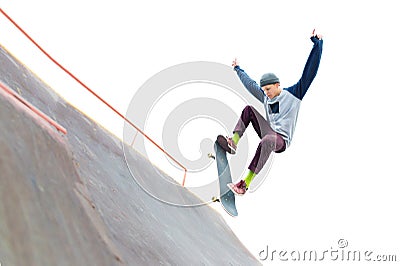 The teenager skateboarder in the cap does a trick with a jump on the ramp in the skatepark. Isolated skater and ramp on Stock Photo