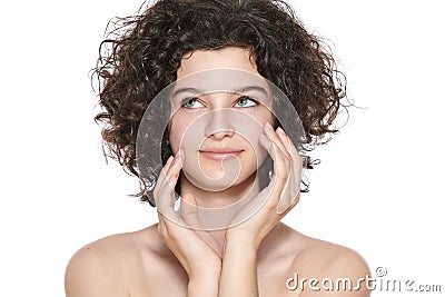 Teenager skincare. Beautiful teenage girl with gorgeous curly hair and perfect skin touching her face. Stock Photo