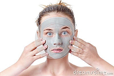 Teenager skincare concept. Young teen girl with dried clay facial mask making funny face, isolated on white Stock Photo