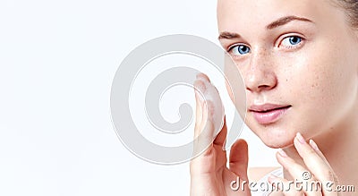 Teenager skincare. Smiling beautiful teen girl with freckles and blue eyes using foaming cleanser. Face washing concept Stock Photo