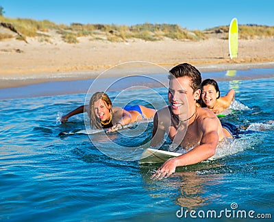 Teenager surfer boys and girls swimming ove surfboard Stock Photo