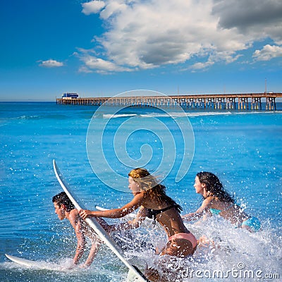 Teenager surfers running jumping on surfboards Stock Photo