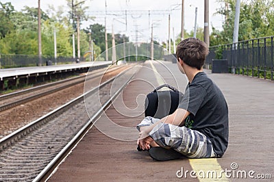 Teenager is waiting for a train to station Stock Photo