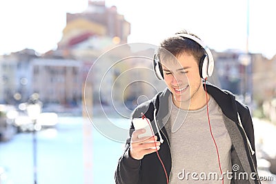 Teenager walking listening music from smart phone Stock Photo