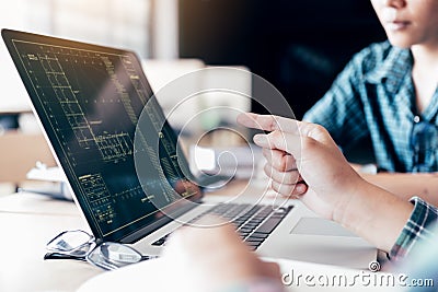 Teenagers develop programming with blueprint code in laptop monitor. Stock Photo