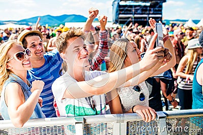 Teenagers at summer music festival in crowd taking selfie Stock Photo