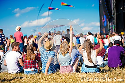 Teenagers, summer music festival, sitting in front of stage Stock Photo