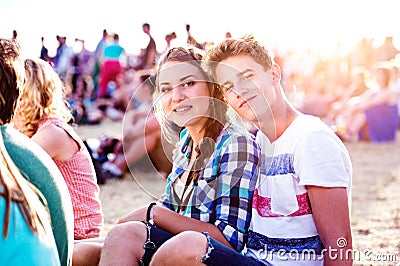 Teenagers at summer music festival, sitting on the ground Stock Photo