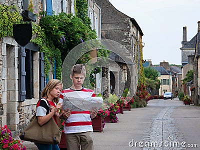 Teenagers travel concept. Children with map walking in the street of an old town, historical centre of the town, Rochefort-en- Stock Photo