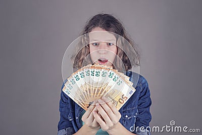 Teens girl holds in her hand euro Stock Photo