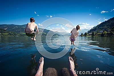 Teens jumping into lake Stock Photo