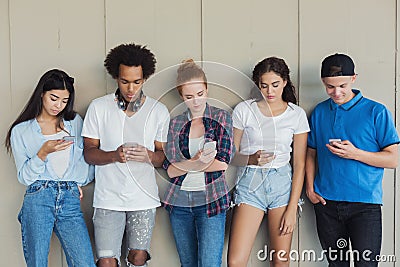Teens using cellphones, disinterested to each other Stock Photo