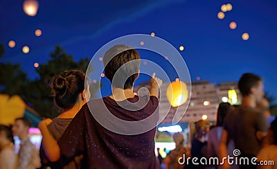 Teens watching paper flying lanterns Stock Photo