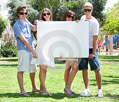 Teens with white billboard standing in park Stock Photo