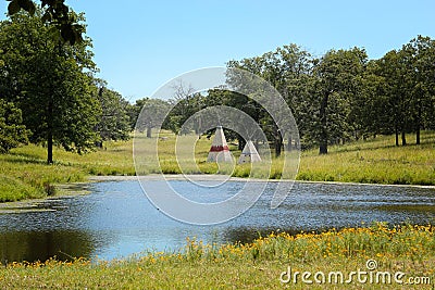 Teepees behind a small lake Stock Photo