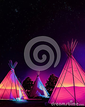 Teepees glowing colorfully at night under stars in Marfa, Texas Stock Photo