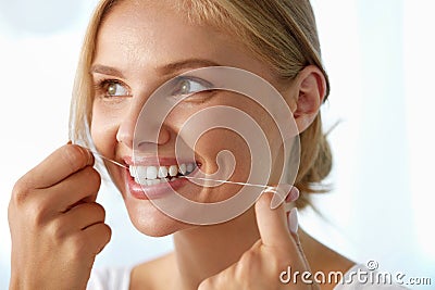 Teeth Care. Beautiful Smiling Woman Flossing Healthy White Teeth Stock Photo
