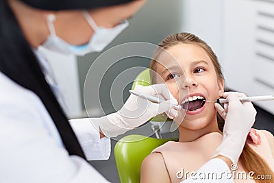 Teeth checkup at dentist's office. Dentist examining girls teeth Stock Photo