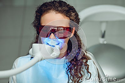 Teeth whitening for woman. Bleaching of the teeth at dentist clinic. Front view Stock Photo