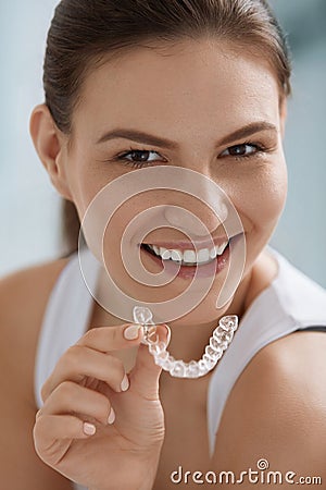 Teeth whitening. Woman with healthy teeth using removable braces Stock Photo