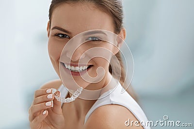 Teeth whitening. Woman with healthy teeth using removable braces Stock Photo