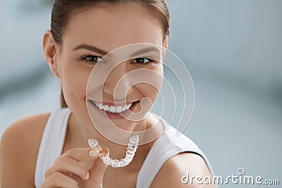 Teeth whitening. Woman with healthy teeth using removable braces Stock Photo