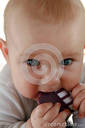 Teething baby boy with a toy Stock Photo