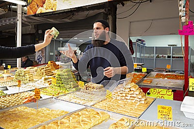 A young man selling sweet dessert baklava Editorial Stock Photo