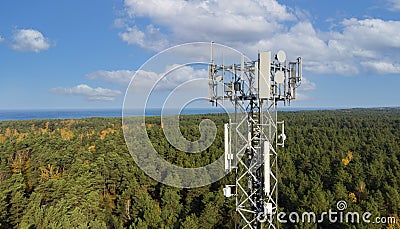 Telecommunication tower with antennas for 5g network on forest and blue sky background. mobile internet broadcast Stock Photo