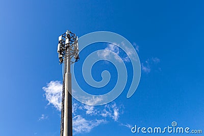 Telecommunication tower with microwave equipment, radio panel antennas, outdoor remote radio units, power cables, coaxial cables, Stock Photo