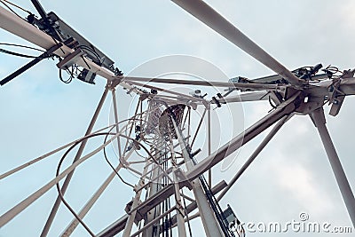 Telecommunication tower with vertical panel antenna and remote radio unit, power and optic cables and sky Stock Photo