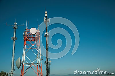 Telecommunication towers with antennas and blue sky Stock Photo