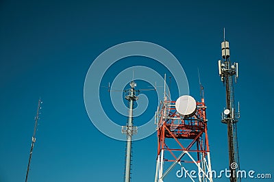 Telecommunication towers with antennas and blue sky Stock Photo