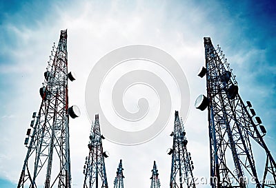 Telecommunication towers with TV antennas and satellite dish on clear blue sky Stock Photo