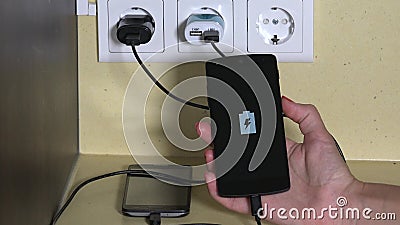 Telefone esperto do anexo fêmea da mão para murar o carregador e guardá-lo video estoque Telefone esperto do anexo fêmea da mão para murar o carregador e guardá-lo video estoque
