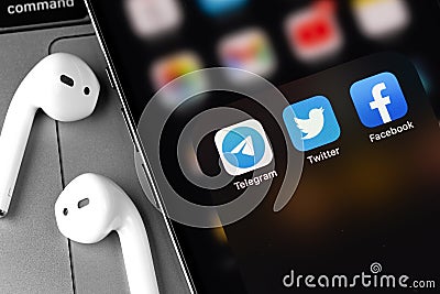 Telegram, Twitter, Facebook - social media mobile messengers icons apps on screen smartphone iPhone with AirPods Editorial Stock Photo