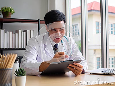 Telemedicine Coronavirus concept. Doctor working with mobile phone and stethoscope and digital tablet laptop in modern office at Stock Photo