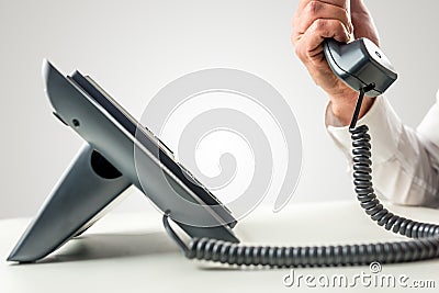 Telephone with the receiver held by a male hand Stock Photo