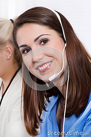 Telesales or helpdesk - happy pretty woman in blue with headset Stock Photo