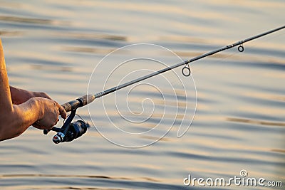 telescopic fishing rod with inertia reel in men's hands Stock Photo