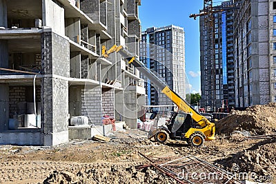 Telescopic handler work at the construction site. Construction machinery for loading. Tower crane during construct a multi-storey Stock Photo