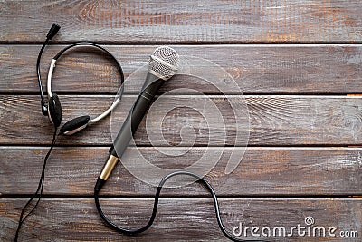 Television concept. Microphone and headset on dark wooden background top-down copy space Stock Photo