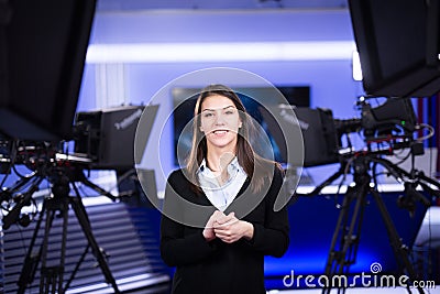 Television presenter recording in news studio.Female journalist anchor presenting business report,recording in television studio Stock Photo