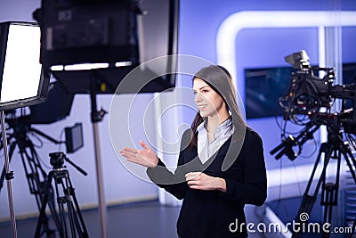 Television presenter recording in news studio.Female journalist anchor presenting business report,recording in television studio Stock Photo