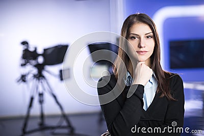 Television presenter recording in news studio.Female journalist anchor presenting business report,recording in television studio Stock Photo