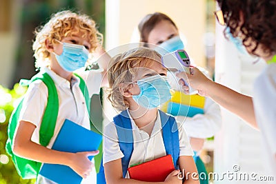 Temperature check at school. Child in mask Stock Photo