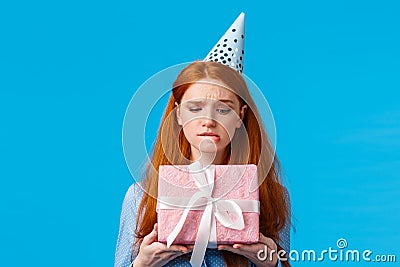 Tempting moment of unwrapping gift. Cute glamour redhead teenage girl biting lip eager open cute birthday present Stock Photo