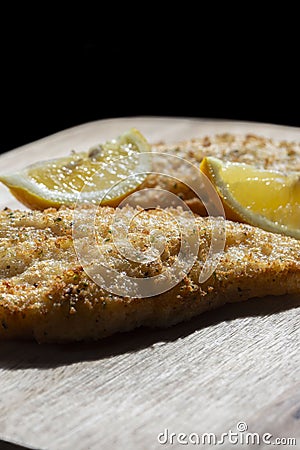 Tempura battered cod fillets coated with herbs and lemon with a slice of lemon. Stock Photo